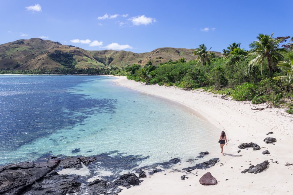 woman walking on beautiful beach on nacula island in fiji